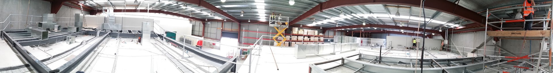 Panoramic view of a large commercial building interior during fit-out