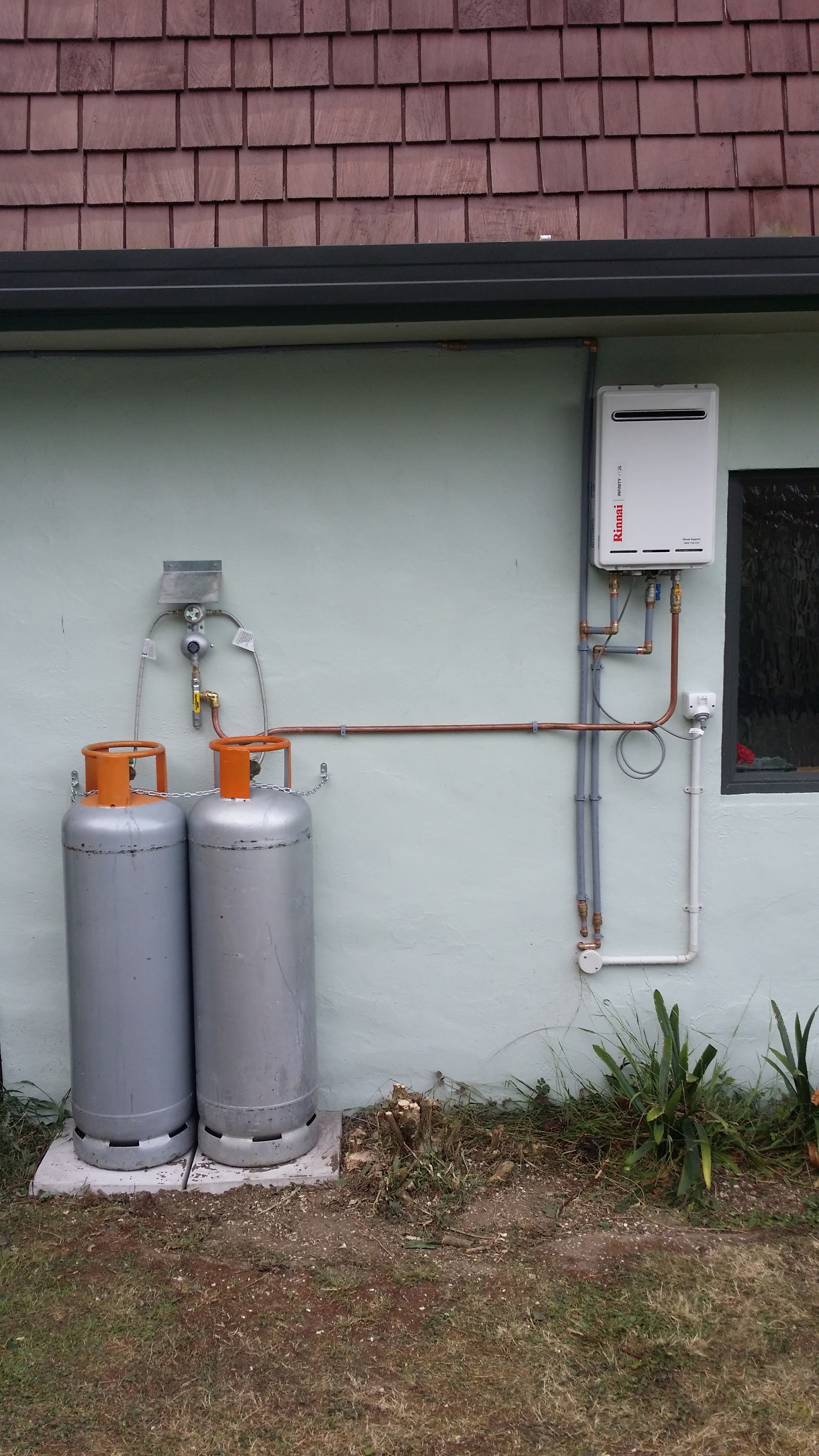 LPG gas bottles and Rinnai instant hot water unit installed on exterior wall